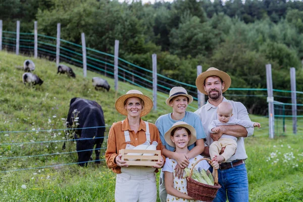 パドックの前に新鮮な野菜でいっぱいの収穫バスケットを持っている農家の家族の肖像画 多世代農業のコンセプト — ストック写真
