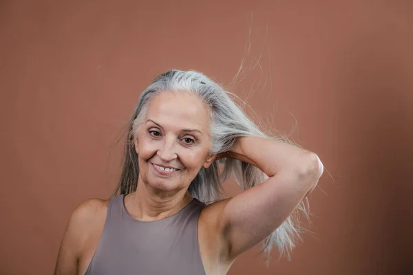 Retrato Estúdio Bela Mulher Sênior Segurando Seu Longo Cabelo Grisalho — Fotografia de Stock