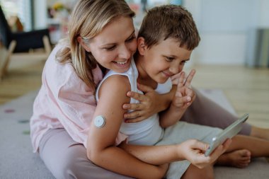 Diabetic boy using a continuous glucose monitor every day, living normal life, video calling his family. The CGM device makes the life of the schoolboy easier, helping manage his illness and focus on clipart