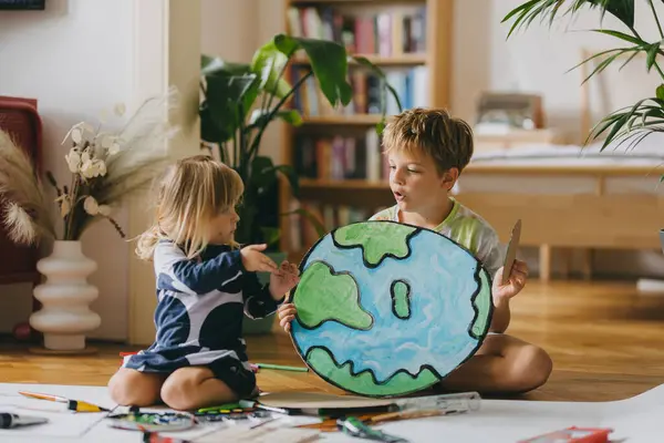 Rodzeństwo Maluje Domu Akwarelami Farbami Temperowymi Tworząc Model Planety Ziemia — Zdjęcie stockowe