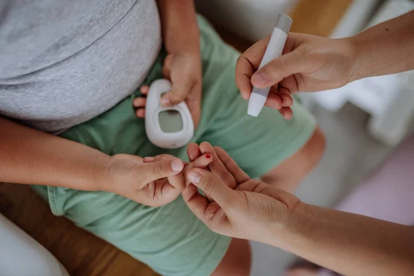 Anne Evdeki Oğullarının Kan Şekeri Seviyesini Parmak Izi Glukometresiyle Ölçüyor — Stok fotoğraf