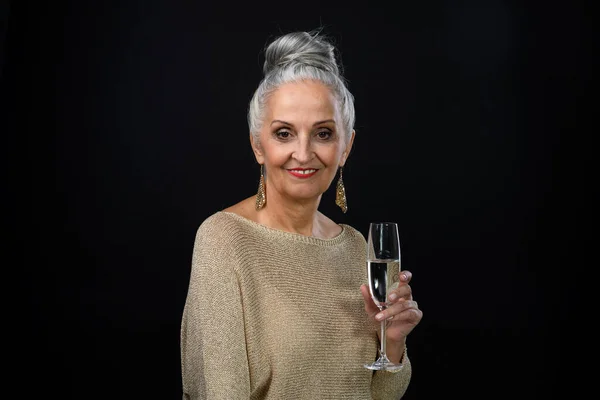 穿着盛装的老年妇女的画像 她手里拿着一杯香槟 庆祝的理念 被隔离在黑色背景下 — 图库照片