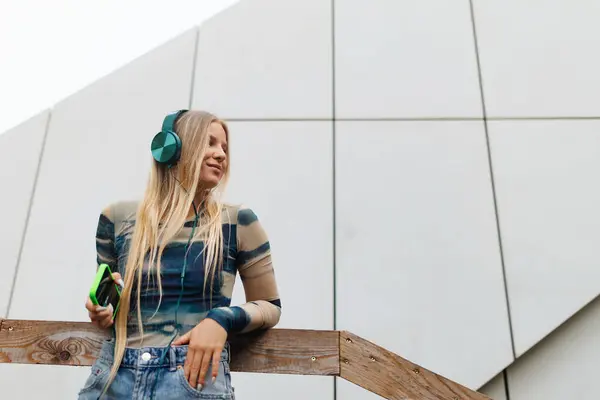 在城市里 一个Z代女生通过耳机听音乐的肖像 学生们在网上和独处的时间 Z基因是最孤独的一代的概念 — 图库照片