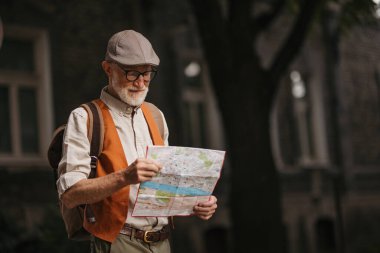 Yeni bir şehri keşfeden, ilginç yerleri keşfeden kıdemli bir turist. Elinde kağıt harita olan yaşlı bir adam güzergahı arıyor. Emeklilikte seyahat ve seyahatler.