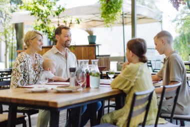 Çocuklu büyük bir aile ve bir restorandaki aile yemeğinde küçük bir bebek. Aile dostu restoranda küçük bir aile kutlaması..