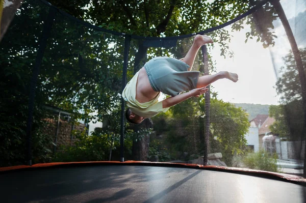 小女孩在后院里跳蹦床 翻筋斗 儿童踩踏线的危险和风险 — 图库照片