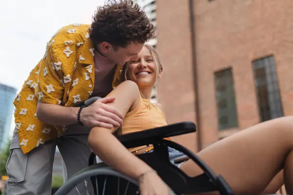 Beautiful gen Z girl in a wheelchair with her boyfriend. Inclusion, equality, and diversity among Generation Z.