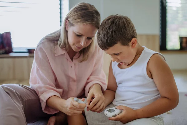 Matka Sprawdza Poziom Glukozy Krwi Swoich Synów Domu Używając Glukometru — Zdjęcie stockowe