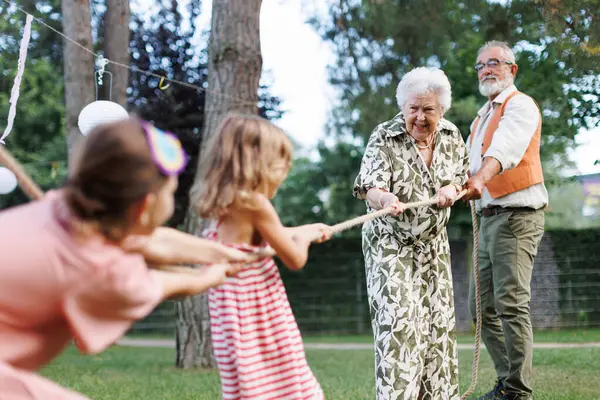 Бабушка Дедушка Перетягивают Канат Своими Внучками Веселые Игры Семейной Вечеринке — стоковое фото
