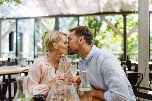 在一个浪漫的约会中 在餐馆里和一对漂亮的夫妇亲密接触 妻子和丈夫接吻 在餐厅庭院里共度浪漫时光 — 图库照片