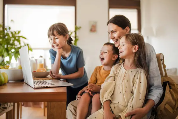 ママと子供たちは お母さんの仕事のラップトップで面白いビデオを見ています 子供とシングルマザーのためのリモートワークとホームオフィス — ストック写真