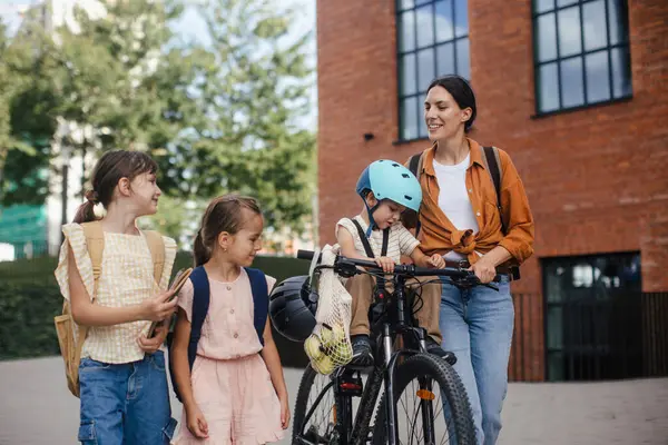 Mom Picking Daughters School Little Son Bike Seat Schoolgirls Telling — Stock Photo, Image