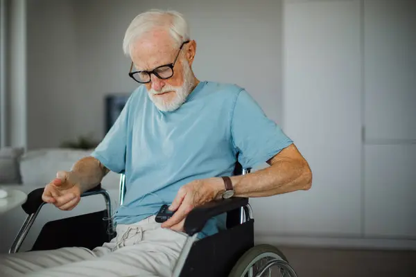 インスリンポンプで血糖値を調べた上級男性 1型糖尿病の車椅子のシニア男性の閉鎖 — ストック写真