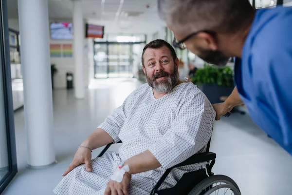 介護看護師は 車椅子で心配する患者を心配しました 中年男性の健康における病気や病気 ストレスを受けた患者と話す思いやりのある医師 オーバーワイトの健康リスクの概念 — ストック写真