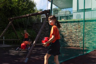 Futbol oynayan, futbol forması giyen kardeşler. Aile tek bir futbol takımı olarak. Arka bahçede ya da sokakta eğlenceli aile spor aktiviteleri.