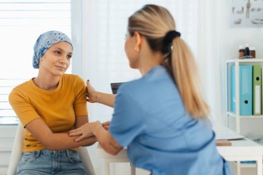 Ergen onkoloji hastası doktorla konuşuyor. Onkolojist, kanserli genç bir kızı tedavi ediyor ve ona duygusal destek veriyor. Endişe ve depresyon konusunda yardımcı oluyor..