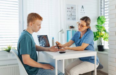 Diyabetolog doktor kan örneğini diyabet kliniğinde kan şekeri ölçer. Doktor oğlanların parmağından kan örneği alıyor. Genç çocukta pediatrik diyabet, genç adam..