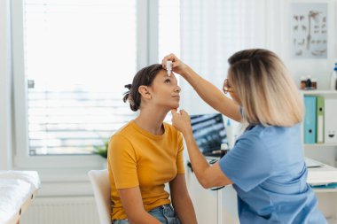 Pediyatrist kızların gözlerine damla damlatıyor. Göz enfeksiyonu, alerji ya da iltihap tedavisi için reçeteli göz damlası kullanılıyor..