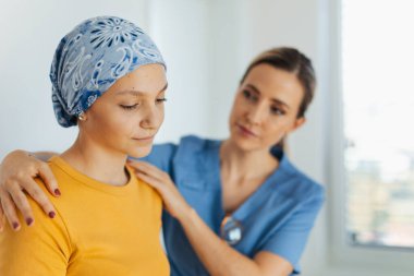Ergen onkoloji hastası doktorla konuşuyor. Onkolojist, kanserli genç bir kızı tedavi ediyor ve ona duygusal destek veriyor. Endişe ve depresyon konusunda yardımcı oluyor..