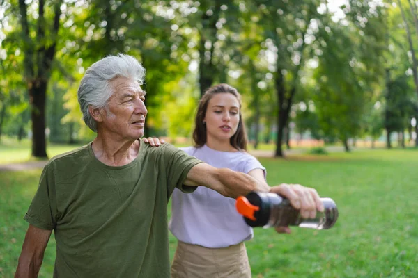 Yaşlı Adam Parkta Egzersiz Yapıyor Dambıl Olarak Şişesi Kullanıyor Genç — Stok fotoğraf