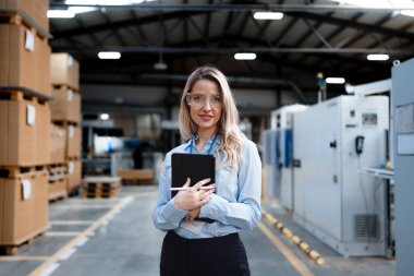 Modern endüstriyel fabrikada duran kadın yöneticinin portresi. Robot ve otomasyonlu üretim tesisi. Kadın lider, ağır sanayi CEO 'su, imalat..