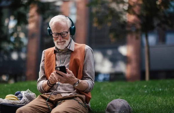Şehir Parkında Oturmuş Kablosuz Kulaklıkla Müzik Dinleyen Şık Bir Son — Stok fotoğraf