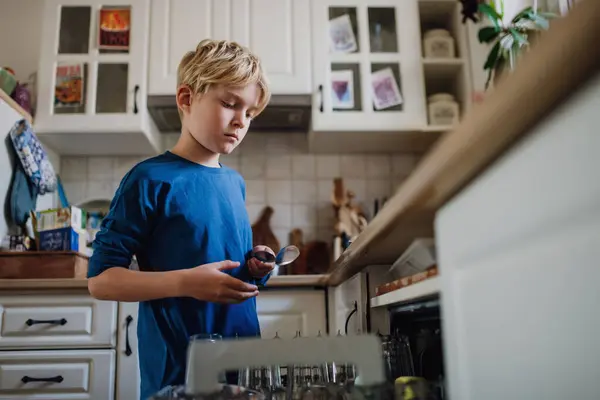 朝食後に食器洗い機を積むのを手伝っている少年 キッチンを掃除してから学校に通う 家族の朝のルーチン — ストック写真