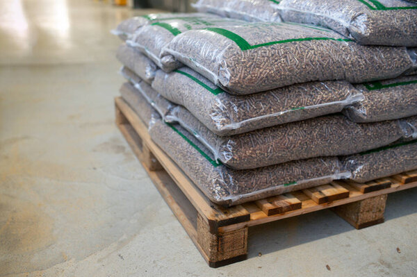 Bags with wood pellets, pellet fuels manufactured in wood pellet line. Reusing wooden industrial waste, sawdust.