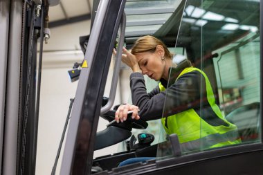 Forklift kullanan kadın depo işçisinin portresi. Depo işçisi nakliye, teslimat ve depodaki stokları kontrol etmek için ürünler hazırlıyor..