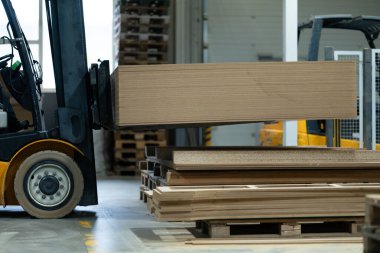 Depoda çalışan forklift 'i kapatın. Endüstriyel asansör, jitney kaldırma ve modern fabrikada malzeme taşıma.