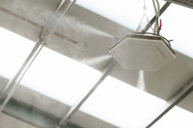 Modern üretim fabrikasındaki endüstriyel toz kontrol sistemi. Su sisi ile toz bastırma, ince su sisi oluşturma, nemli toz parçacıkları.