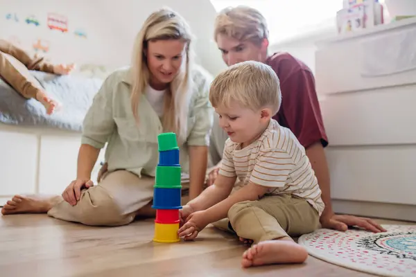 子供部屋にタワーを建てる小さな男の子を見ている親 スタッキングブロック プリスクーラー用ゲームの構築 — ストック写真
