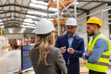 Kadın mühendis, ustabaşı modern sanayi fabrikasının müdürüne danışmanlık yapıyor, yeni üretim projesi, yatırım hakkında konuşuyor. Üretim tesisinde takım yönetimi.