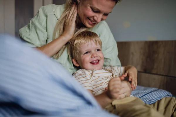 朝起きているかわいい赤ん坊の肖像画 ベッドから息子を助ける母 — ストック写真