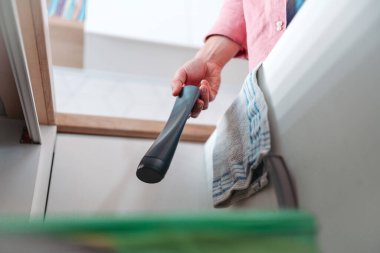 Adam plastik şişeyi geri dönüşüm kutusuna atıyor. Atık maddeleri mutfaktaki renkli kutulara göre ayırmak. Duş jeli şişesi geri dönüşümü.