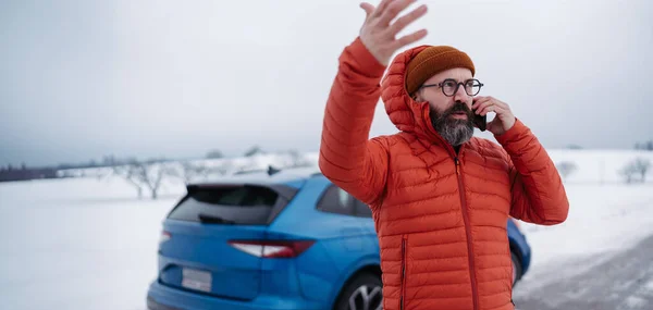 stock image Angry man standing by electric car, battery run out of power before reaching destination. Man phone calling for help, waiting for the breakdown service car, tow truck.