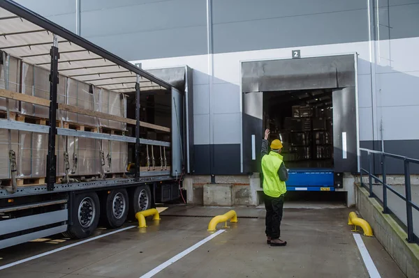 倉庫は倉庫の前にトラックの荷を下ろし 渡された項目を点検します 貨物の荷を下すこと — ストック写真