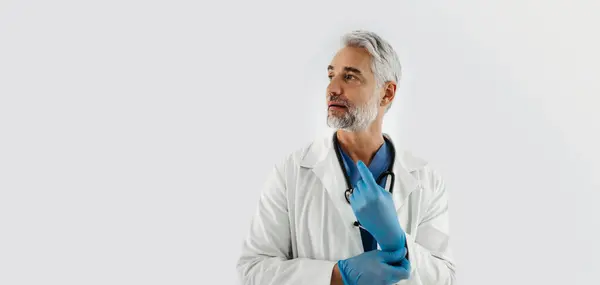 Confident Mature Doctor Putting Medical Examination Gloves Handsome Doctor Gray — Stock Photo, Image