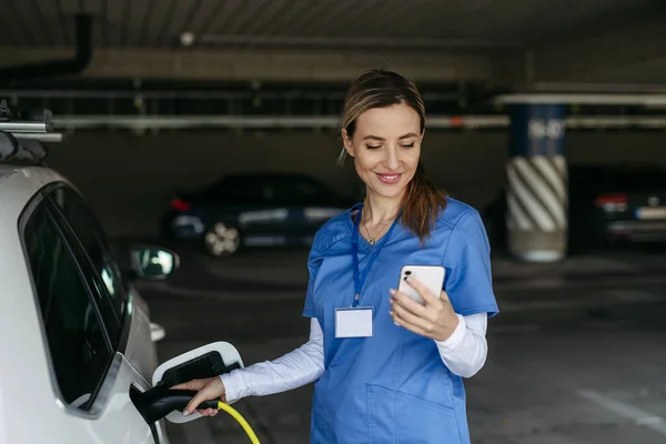 Nurse Plugging Charger Her Electric Car Going Work Electric Vehicle — Stock Photo, Image