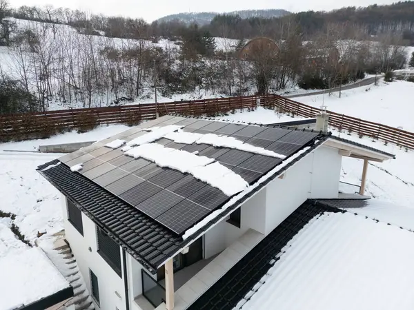 Roof solar panels with snow on top of them. Solar energy in the winter.