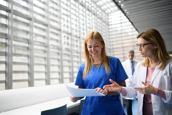 Two Female Doctors Discussing Test Results Walking Corridor Colleagues Discussing — Stock Photo, Image