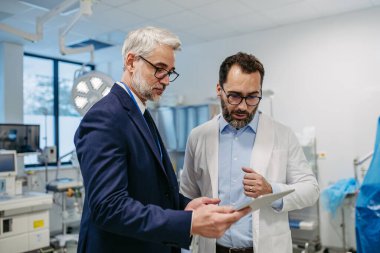 İlaç satış temsilcisi tıp binasındaki doktora yeni ilaçları sunuyor, ilaç kutusunu tutuyor, uyuşturucu örnekleri....