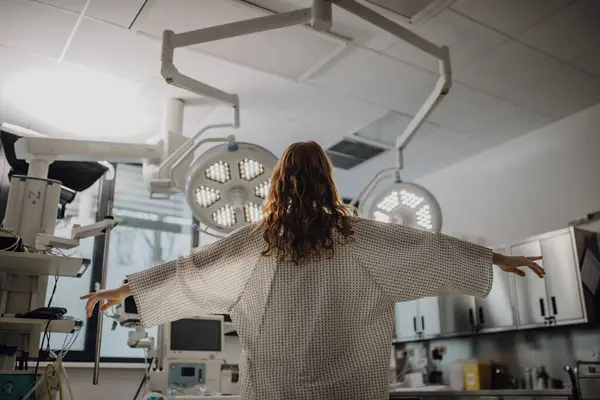 病院の救急処置室で ガウンにいる患者さんの リアビューです 天使のように見える — ストック写真