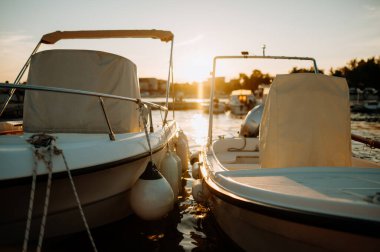 Sakin sularda küçük bir tekne, limanda demirli, gün batımında rıhtımda..