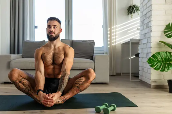 英俊的男人做瑜伽 伸展身体 在家锻炼后休息 新年决心 像健康的生活方式和自我照顾那样锻炼 晨练或晚练的概念 — 图库照片