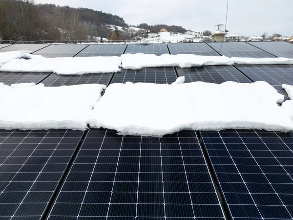 Roof solar panels with snow on top of them. Solar energy in the winter.