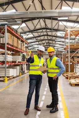 Modern endüstriyel fabrikada ustabaşıyla mühendislik danışmanı yeni üretim projesi, yatırım hakkında konuşuyor. Üretim tesisinde takım yönetimi.