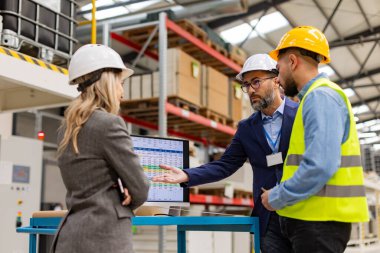 Kadın mühendis, ustabaşı modern sanayi fabrikasının müdürüne danışmanlık yapıyor, yeni üretim projesi, yatırım hakkında konuşuyor. Üretim tesisinde takım yönetimi.
