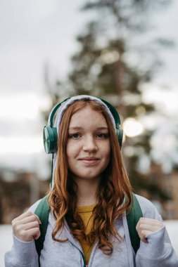 Dışarıdaki güzel kızıl saçlı kız neslinin portresi. Bakır saçlı kız, kafasında kapüşonlu çilli kız..