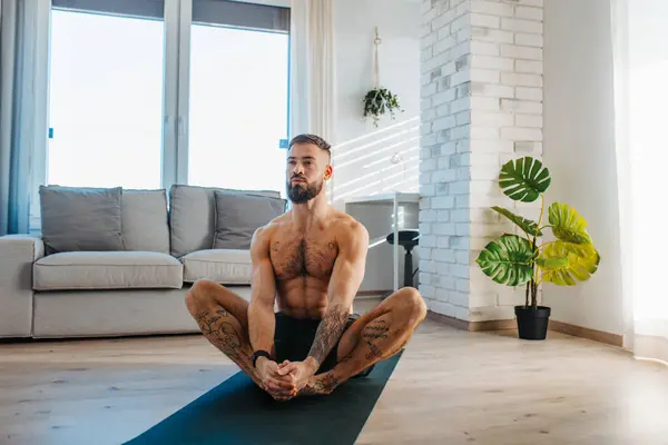 英俊的男人做瑜伽 伸展身体 在家锻炼后休息 新年决心 像健康的生活方式和自我照顾那样锻炼 晨练或晚练的概念 — 图库照片